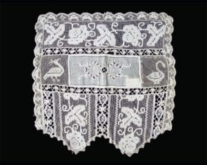 Single example from one of two pairs of lace chair arm covers. Rectangular with lightly scalloped side and back edges and larger scalloped front edge. Inner rectangle with foliate decoration. Original to Castle Tucker (Wiscasset, ME). photo: Historic New England