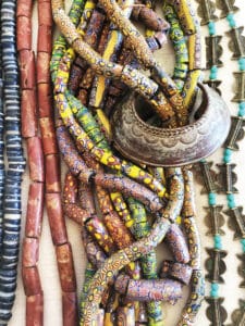 Glass and clay beads of different shapes and colors displayed in