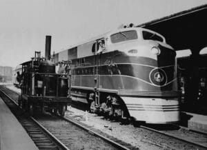 A vintage 1937 original photograph depicting Baltimore & Ohio Railroad introducing its newest with its oldest. The famous Tom Thumb is posed with a shiny EA built by Electro-Motive Corporation of La Grange, Illinois.