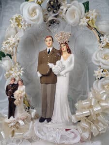 Center: Two World War II-era toppers, with the grooms in military attire. The smaller couple is saltstone, and the larger is chalkware. A highlight of the larger couple is the bride’s “crown,” piled high with pearls (and stabilized by an invisible string). Grooms, 3" h.; 6" h. $35-$50; $150-$175.
