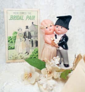 “Here Comes The Bridal Pair” celluloid “huggers,” complete with original box, dating from the 1920s. Marked “Made in Japan.” Groom, 3-1/2” h. $225-$250.