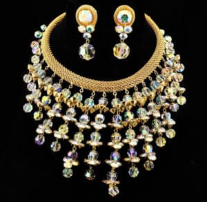 Vintage Hattie Carnegie necklace of iridescent cut crystals and gilt mesh with matching ear clips selling for $685 on eBay