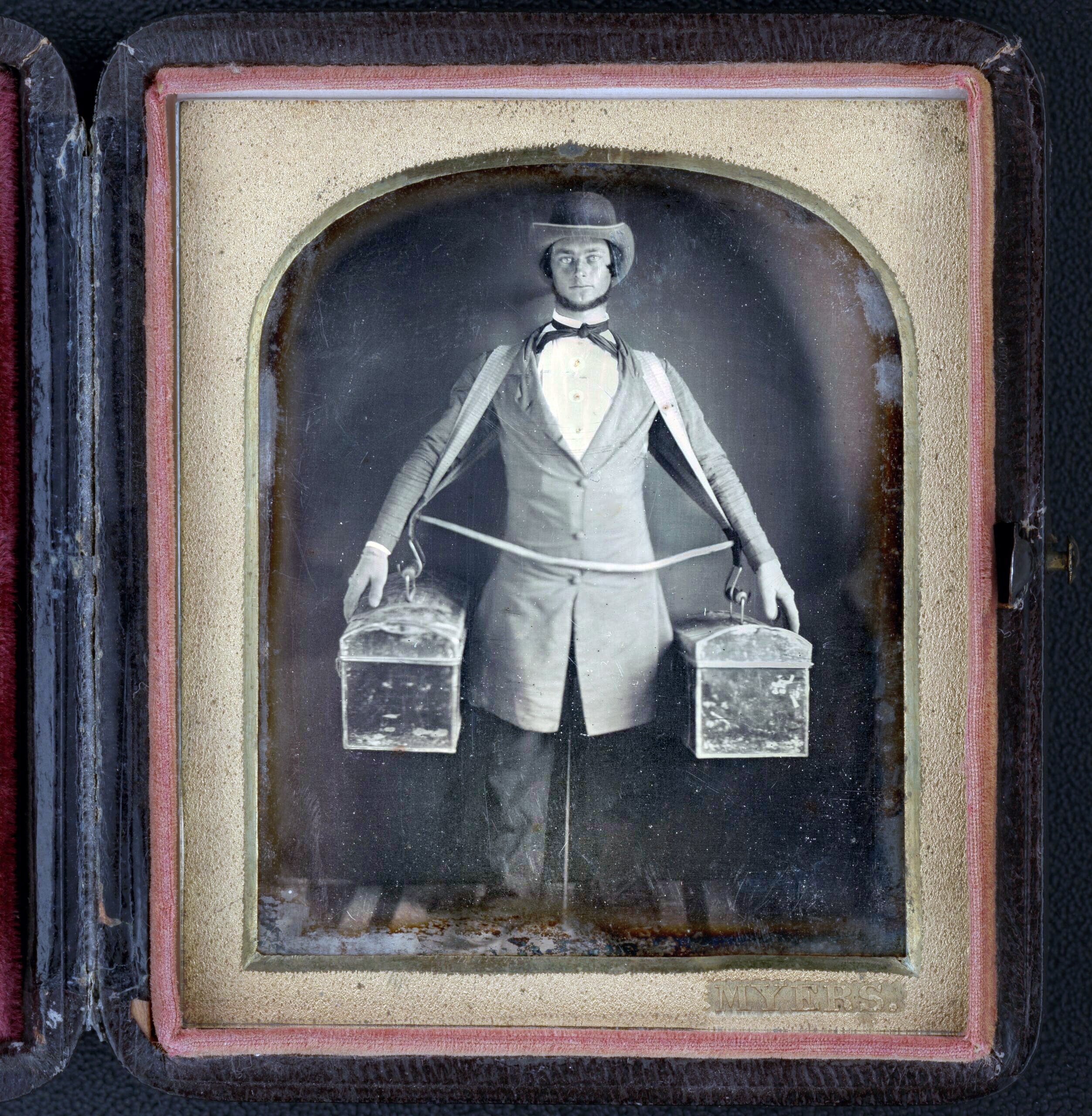 Myers, photographer, Occupational Portrait of a Peddler, Full-Length, Standing, Facing Front, With Two Bags Held at His Sides by a Harness, Neck Brace Visible Between Legs, ca. 1840-1860.