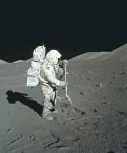 A member of the Apollo 17 mission retrieving moon rocks from the surface of the moon.