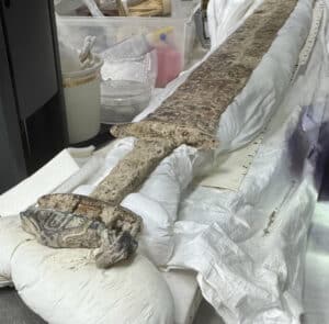 This 6th century sword is made of high-quality craftsmanship. It is being compared to the sword found at Sutton Hoo. The site also contained a gold pendant with a serpent inscribed on it, weapons in men’s graves, knives, brooches, and more.