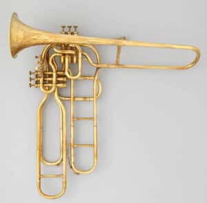This cavalry trombone was built by Adolphe Edouard Sax, the son and successor of the better-known Adolphe Sax who took over his father’s shop at his passing in 1894 and changing the mark to “Sax-fils.” In 1852, Adolphe Sax patented the six ascending valve system. The valves are the reverse of standard valves- by depressing the valve, one bypasses a section of tubing, thus raising the pitch. This 1895 example is selling at Virtuosity Instruments for $6,000.