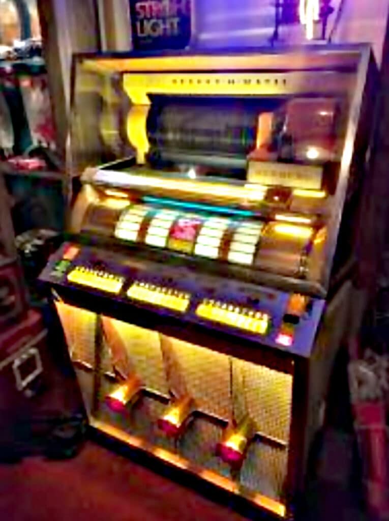 Now this … this beauty right here? This is not just a jukebox – it’s a time capsule. Pulled straight from the legendary Whispering Pines juke joint down in Mississippi. You can almost hear the blues still echoing off the chrome. Every nick, every smudge – it all tells a story. This machine didn’t just play records … it played memories.