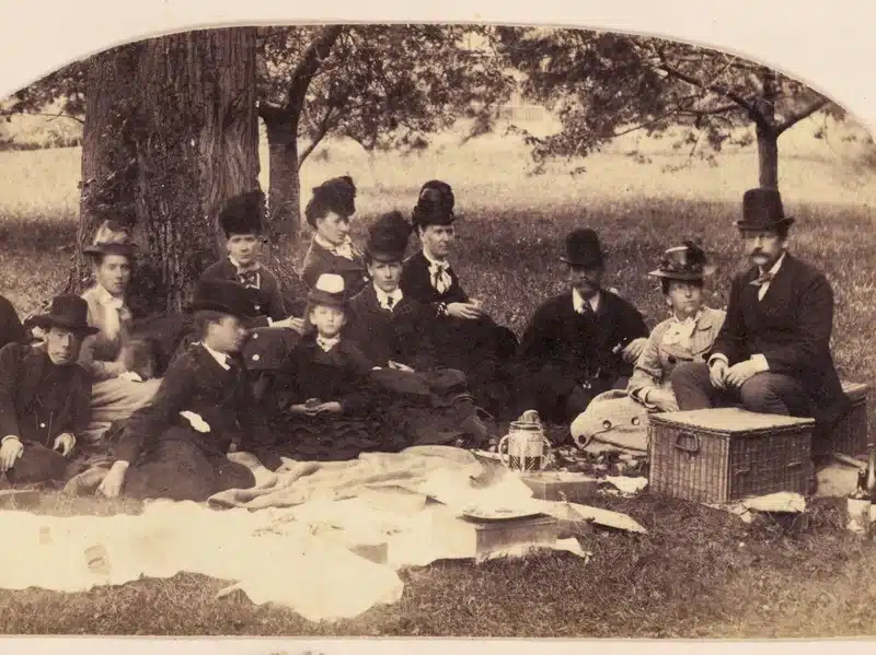 Family enjoying a countryside picnic in 1869.