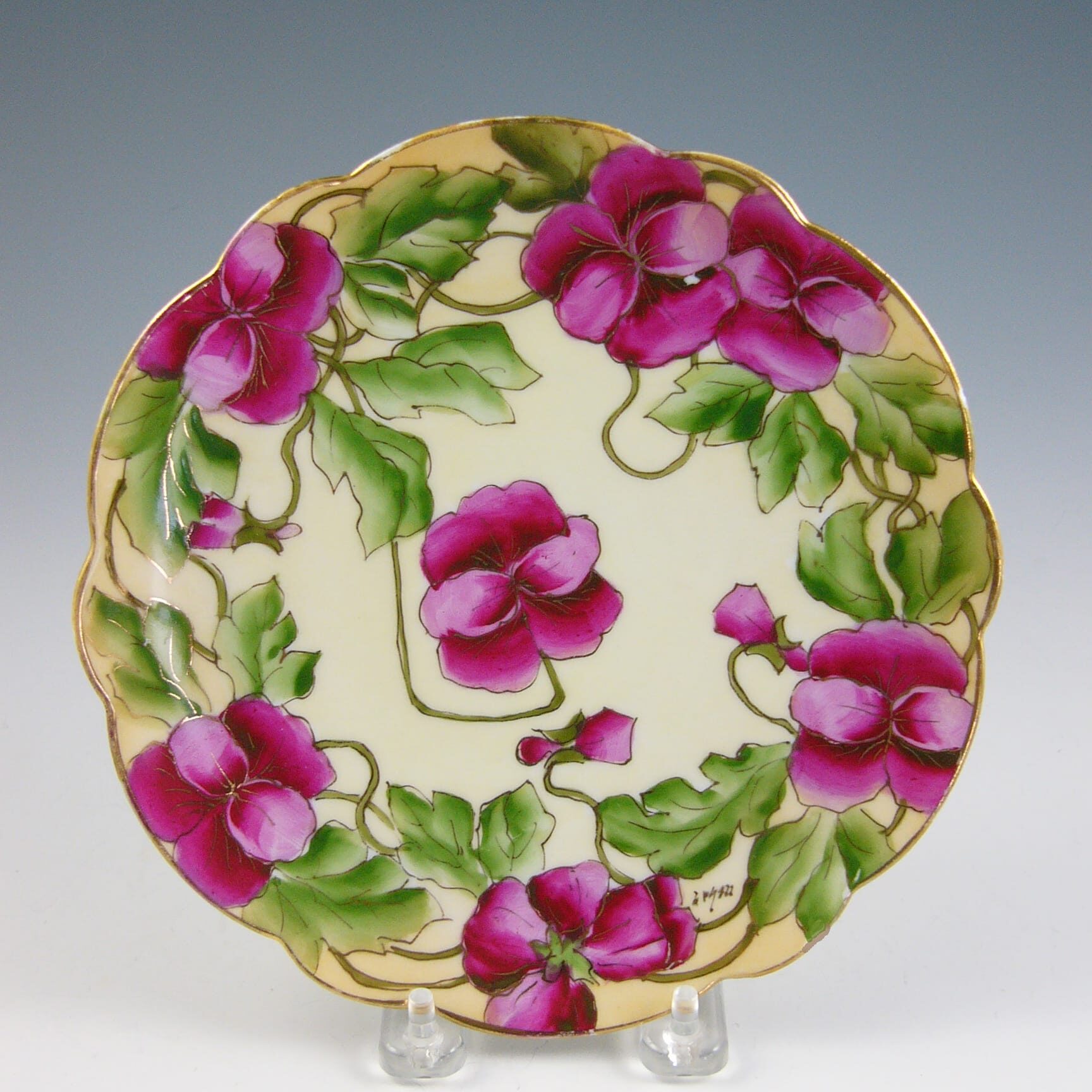 Scalloped-edge plate of pansies, marked “Handpainted, Vienna.”