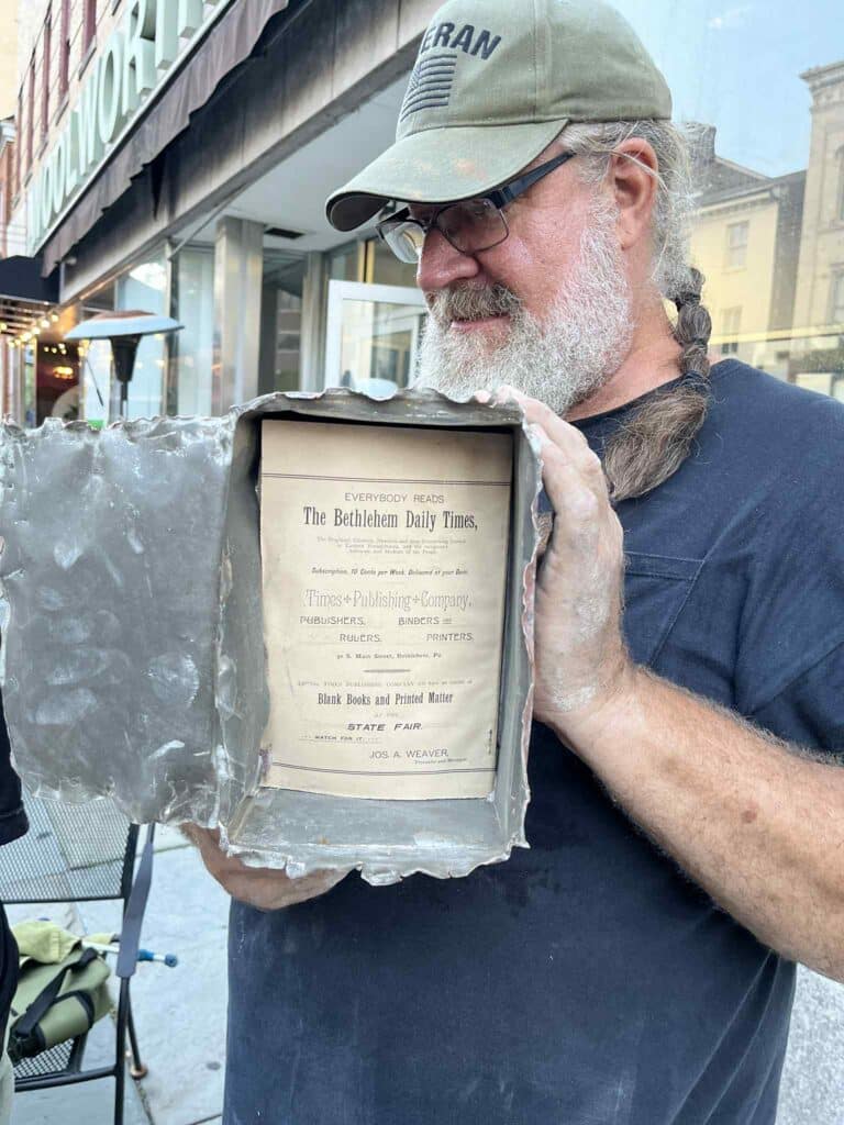 Jack Stanley holds up the opened 
copper box with one of its 
documents still inside.