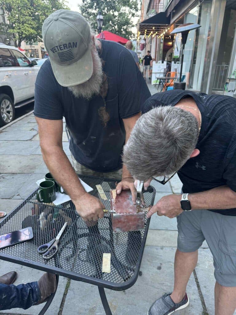 Jack Stanley and Randy Blose used some ingenuity with the tools on hand 
to open the sealed copper box.