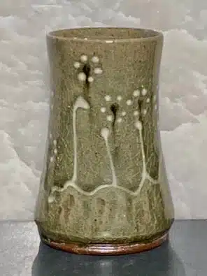 Tumbler, Mark Hewitt Pottery

Green celadon glaze tumbler with floral motif. White stems and white and black blossoms. Lovely variation in the color as you turn it in the light.  Beautiful to the eye and the touch.

Dimensions: 5"H x 3.5"W