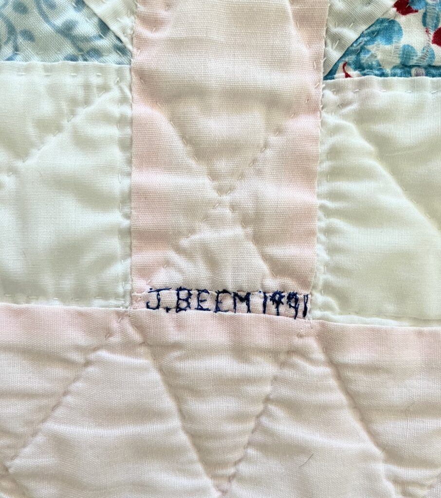 After sewing thousands of stitches for her third granddaughter’s quilt, 
Jean made a few more in 
order to sign and date her work.