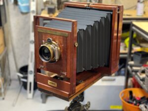 Restored Kodak Favorite large-format field camera with polished mahogany body, brass lens, and custom bellows — a century-old tool built for deliberate photography.